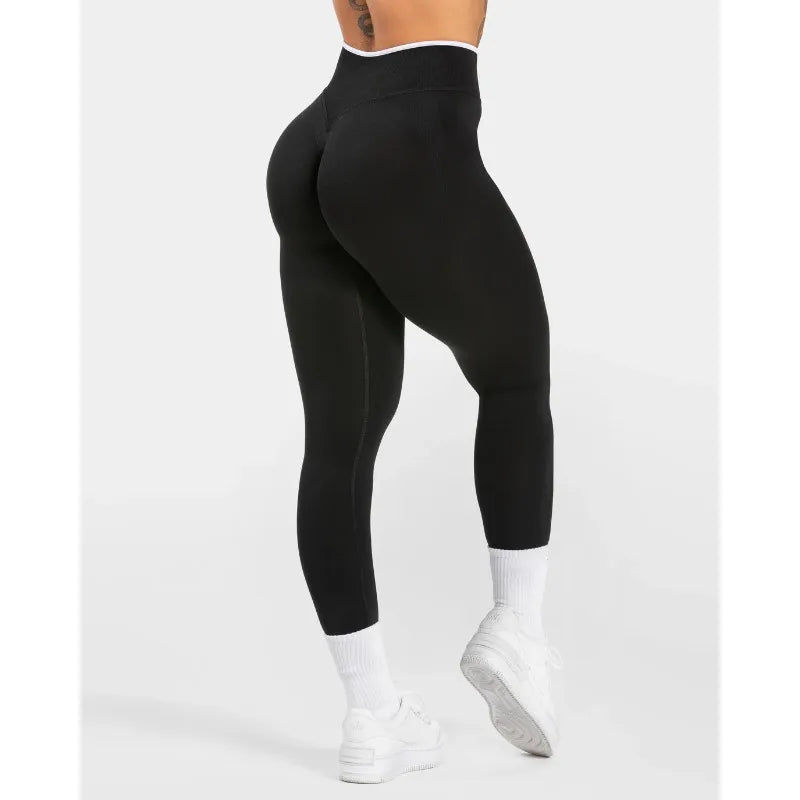 Nuevos leggings deportivos para mujer con diseño de bloques de color. Confección sin costuras, tejido de punto, cintura alta y efecto realce de glúteos. Ideales para yoga, gimnasio y entrenamientos, con detalle de borde blanco.