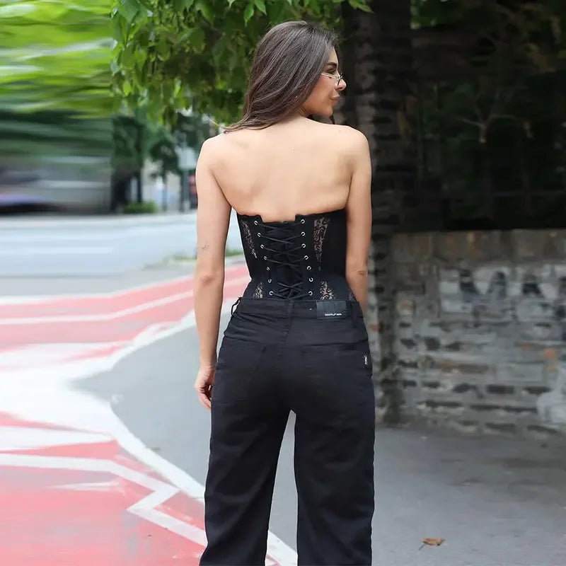 Top tipo corsé ajustado para mujer con encaje y diseño calado. Sin mangas y sin tirantes, con ajuste de cordones para realzar la figura. Estilo sexy y moderno, tendencia streetwear verano 2026.