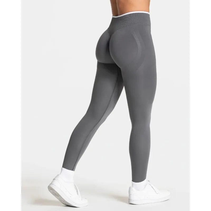 Nuevos leggings deportivos para mujer con diseño de bloques de color. Confección sin costuras, tejido de punto, cintura alta y efecto realce de glúteos. Ideales para yoga, gimnasio y entrenamientos, con detalle de borde blanco.