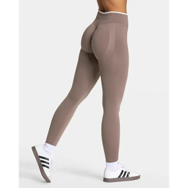 Nuevos leggings deportivos para mujer con diseño de bloques de color. Confección sin costuras, tejido de punto, cintura alta y efecto realce de glúteos. Ideales para yoga, gimnasio y entrenamientos, con detalle de borde blanco.