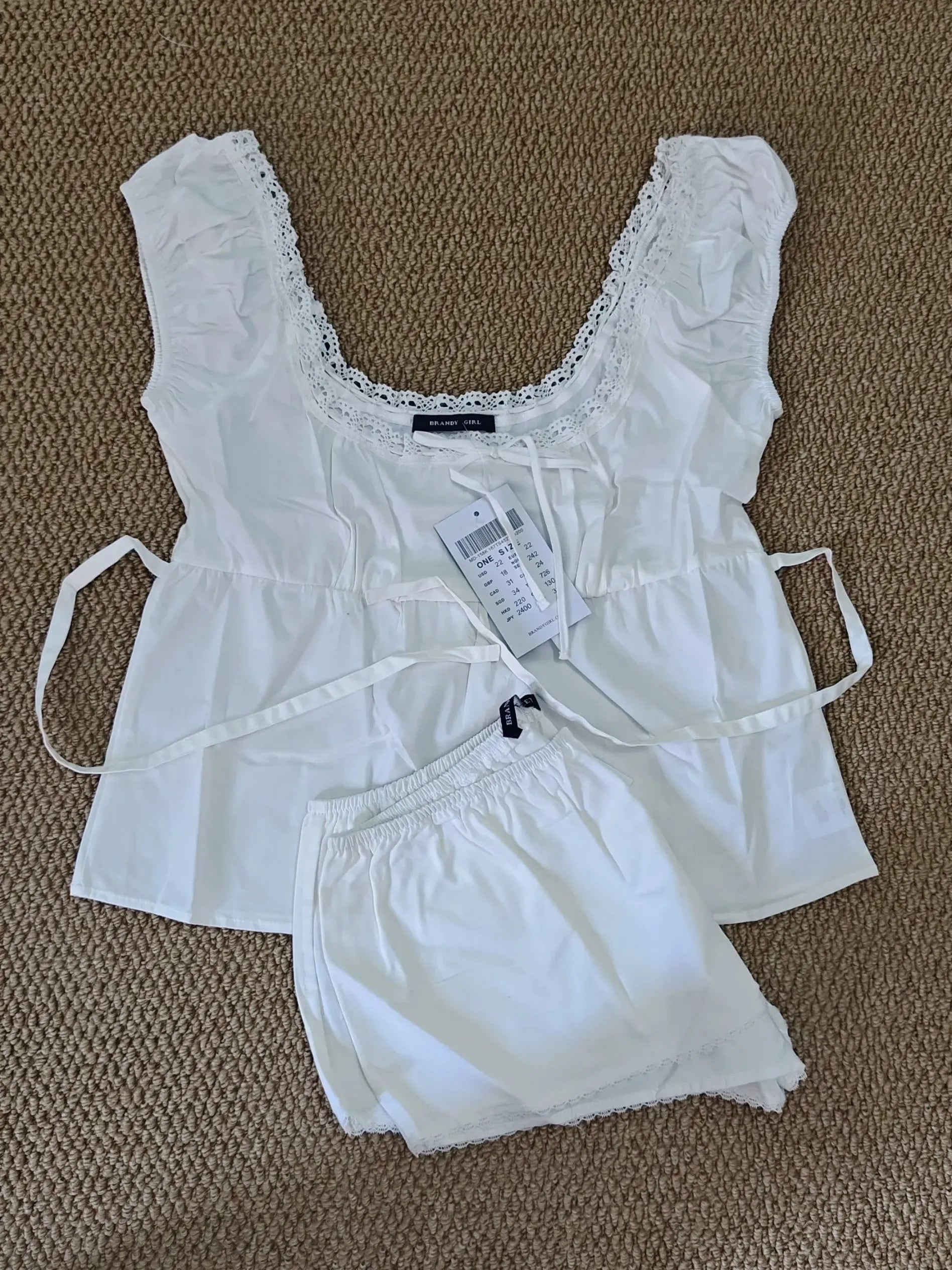 Conjunto de verano para mujer de 2 piezas, compuesto por una blusa de cuadros rojos con mangas abullonadas y detalle de amarre, acompañada de shorts de algodón con botones y cintura elástica. Fresco, cómodo y perfecto para un look femenino y moderno.