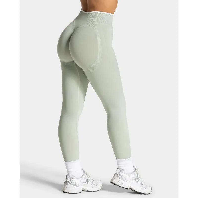 Nuevos leggings deportivos para mujer con diseño de bloques de color. Confección sin costuras, tejido de punto, cintura alta y efecto realce de glúteos. Ideales para yoga, gimnasio y entrenamientos, con detalle de borde blanco.