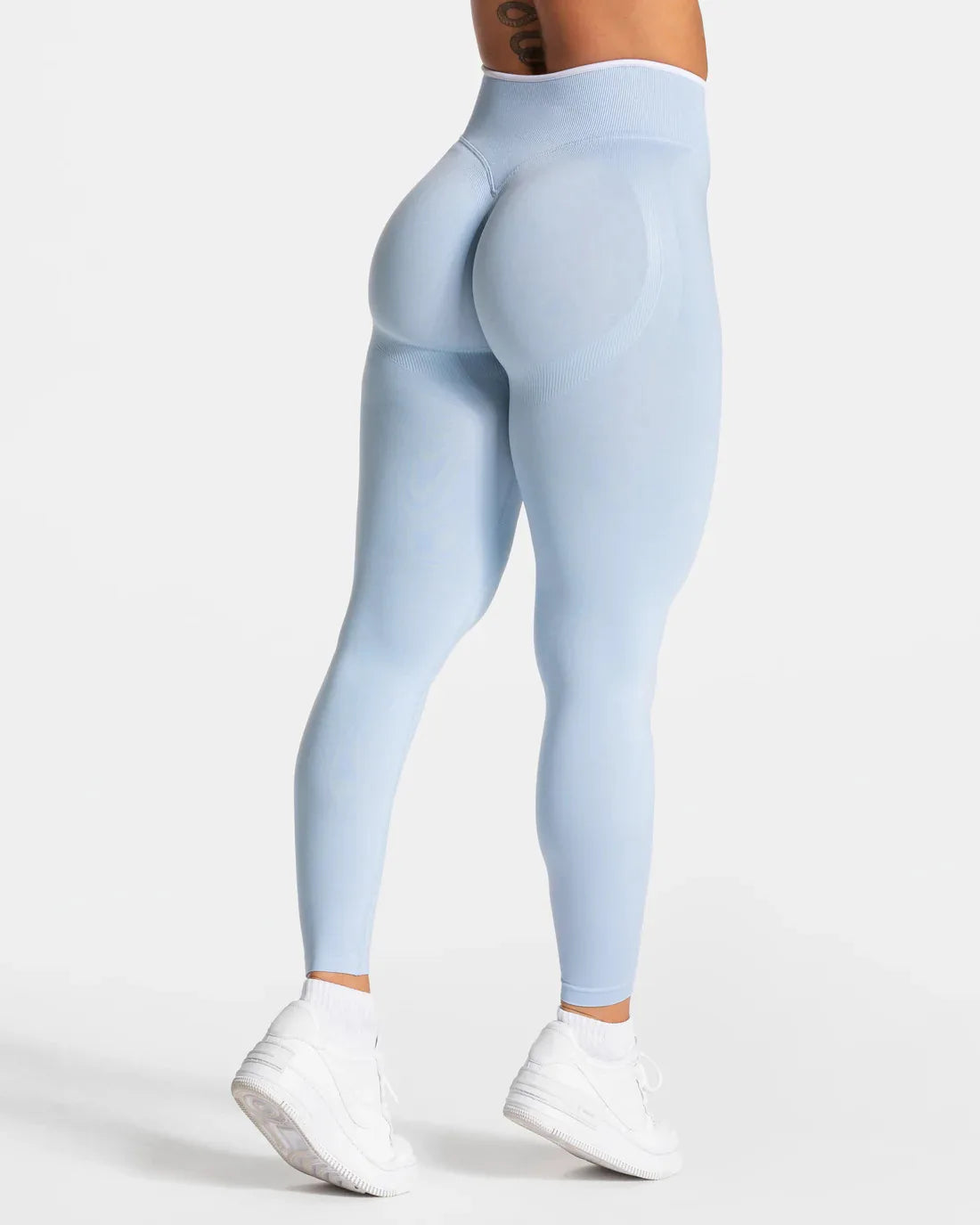 Nuevos leggings deportivos para mujer con diseño de bloques de color. Confección sin costuras, tejido de punto, cintura alta y efecto realce de glúteos. Ideales para yoga, gimnasio y entrenamientos, con detalle de borde blanco.